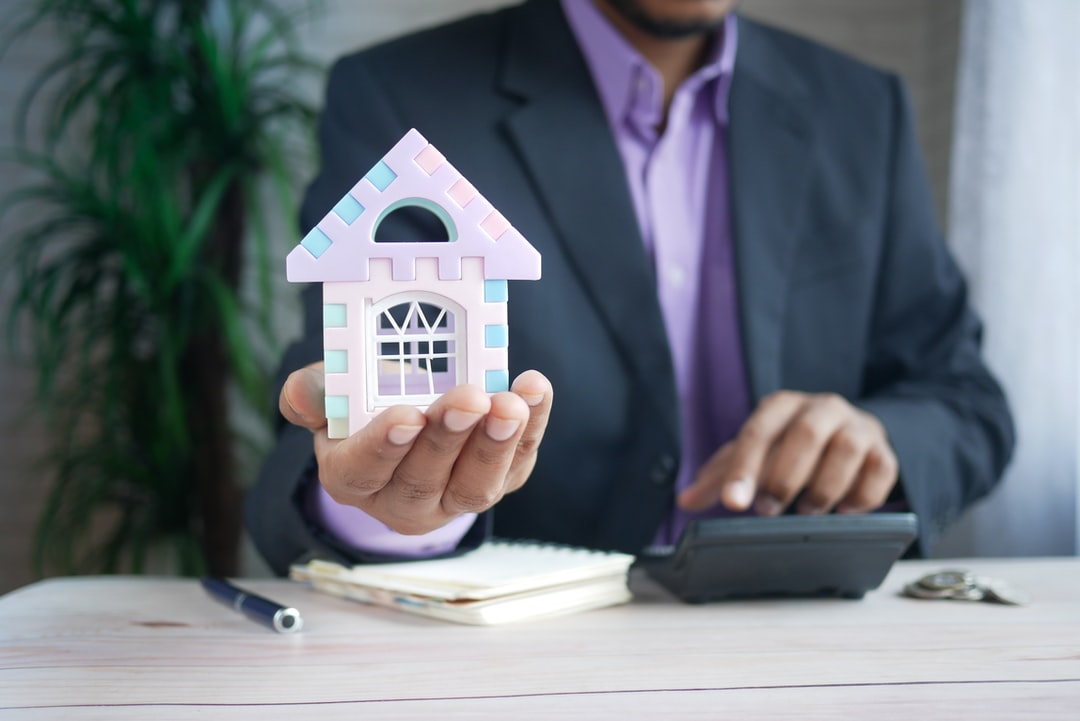 mortage lender holding a little house 