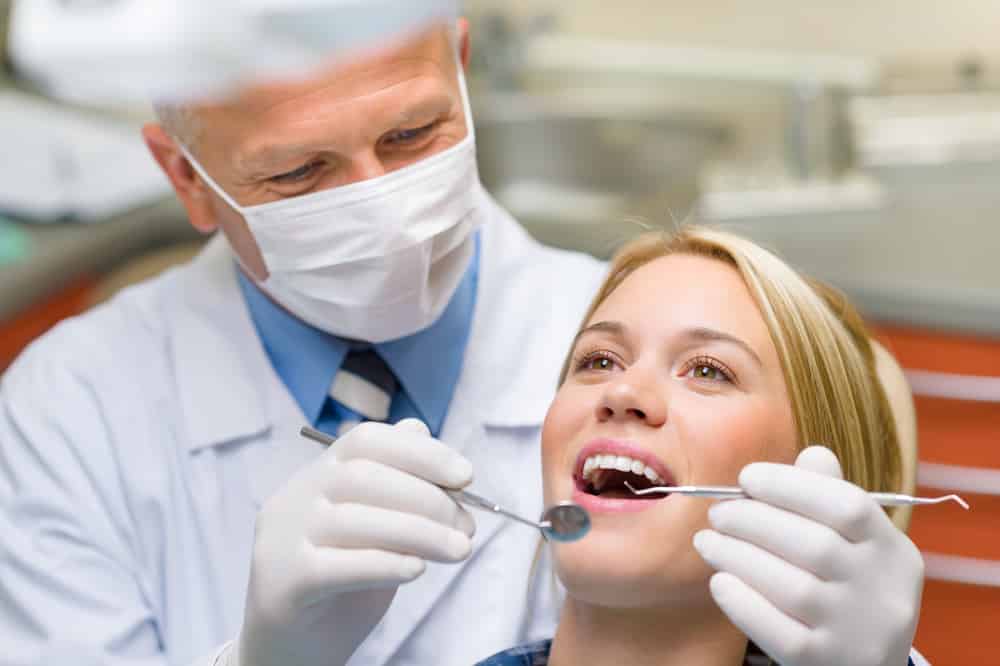 Dental Insurance - Dentist checking her teeth